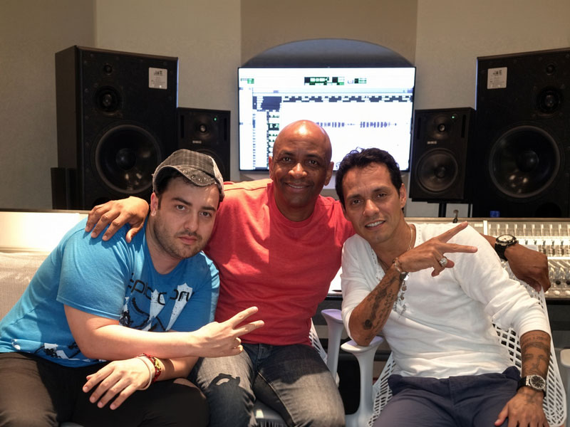 Three collaborators seated together in a recording studio